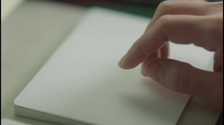 Hand lightly touches a white touchpad