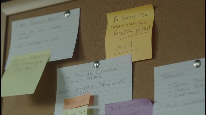 Corkboard with notes on colored papers about trainings and deadlines
