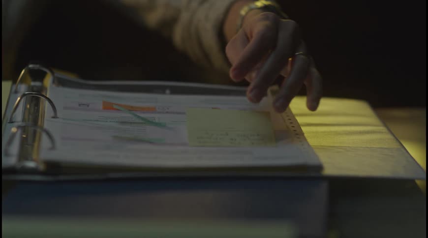 The woman reads a note in the book