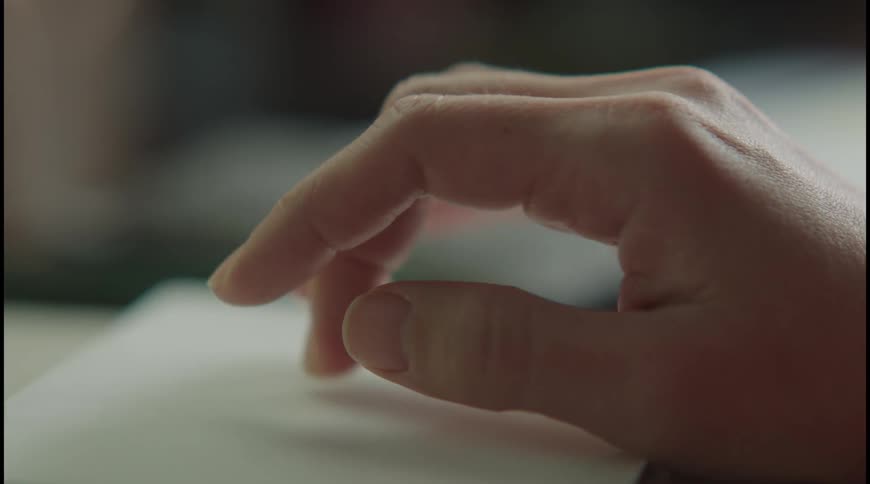 A persons arm operates a laptop typing and scrolling on the trackpad