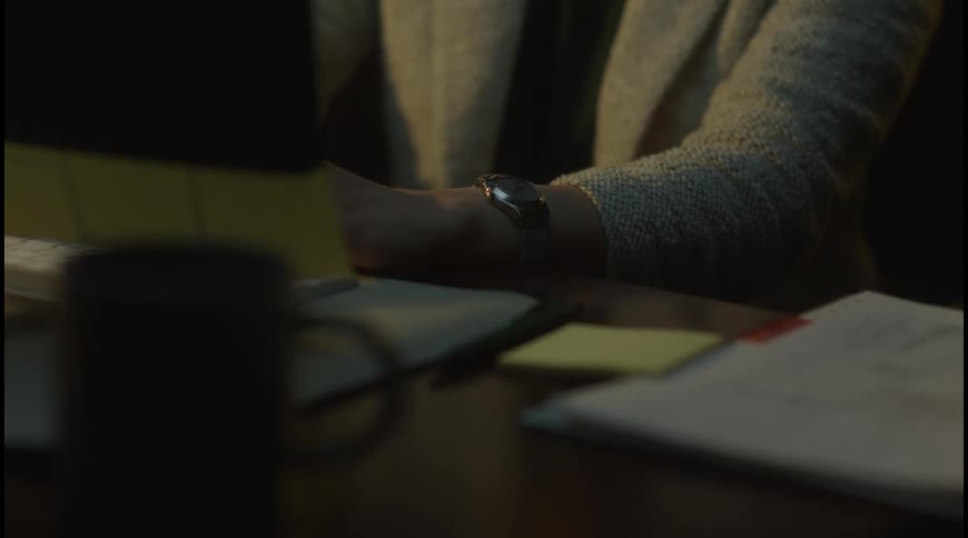 Person types on the keyboard while working at a desk with notes and documents