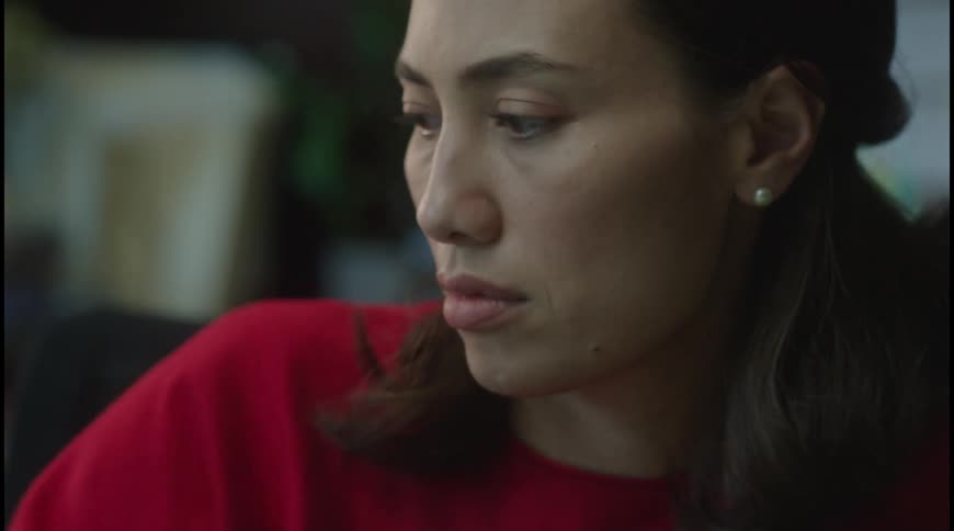 A young woman wearing a red dress works inside an office