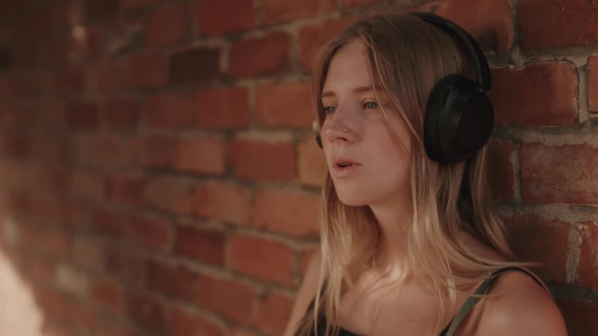 Blonde woman singing while listening to music