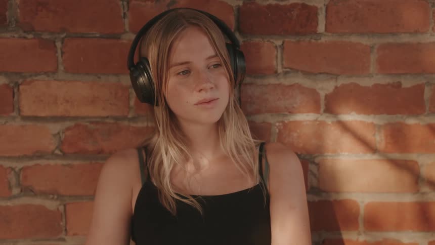 The girl is nodding her head while listening to her headphones