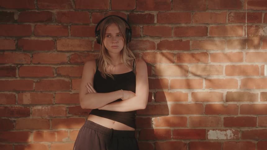 Young woman putting on black headphone
