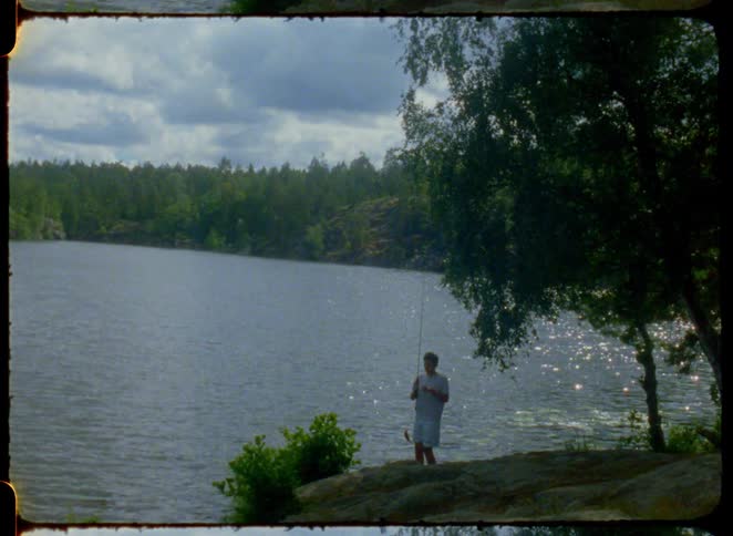 The boy is fishing in the lake