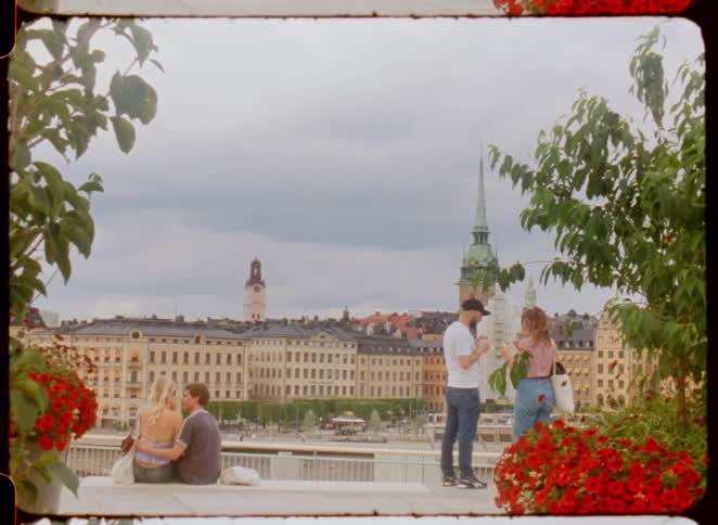 Couples talk at a viewpoint overlooking historic buildings and a church tower