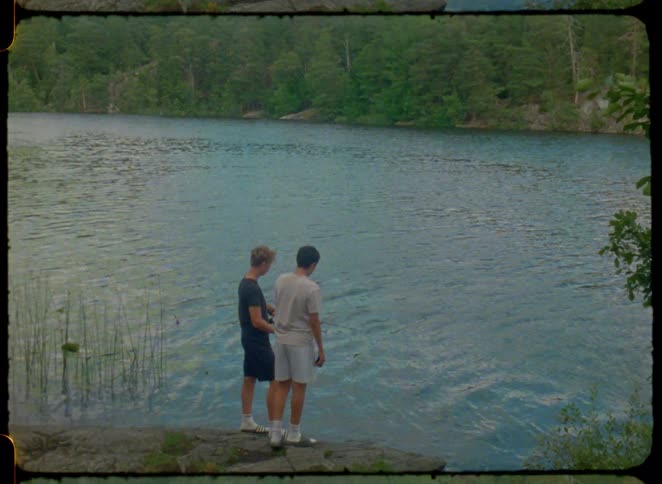 A couple guys fishing on the bank of a river