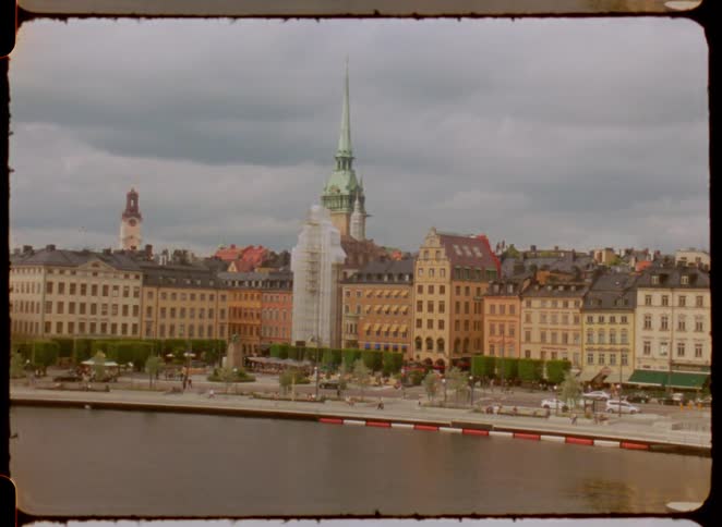 Historic european architecture with colorful buildings and a church tower by the river