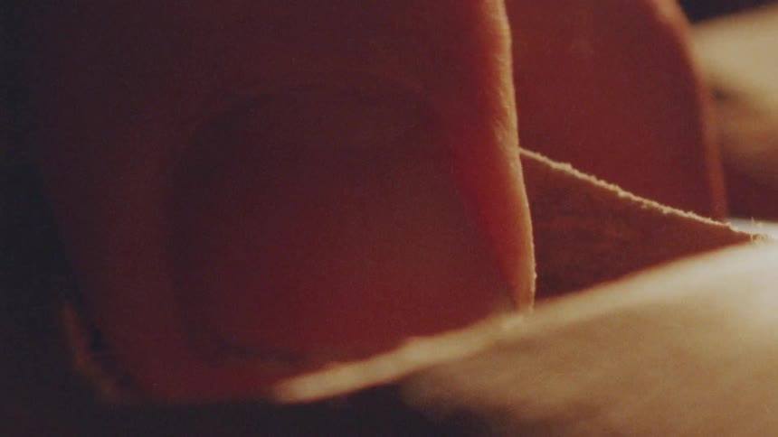 Finger presses sandpaper against the wood during sanding