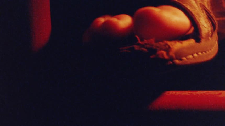 Black leather sandal illuminated by reddish light