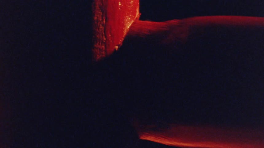 Closeup of a piece of wood being fitted into another piece against a dark background