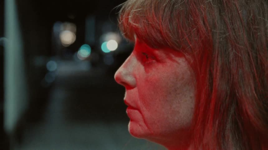 Woman outdoors at night with a red light on her face