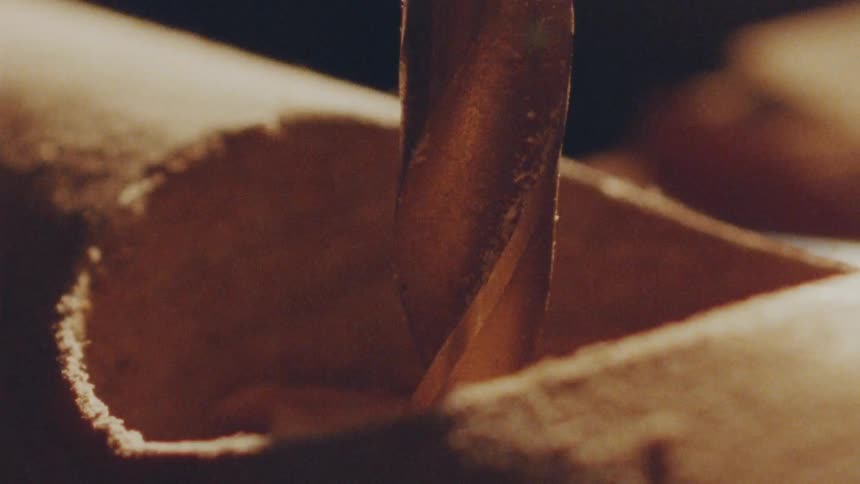 The drill spins in the wood