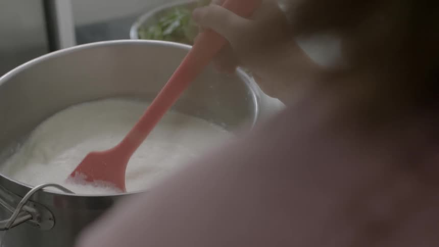 A person is mixing a bowl in a kitchen