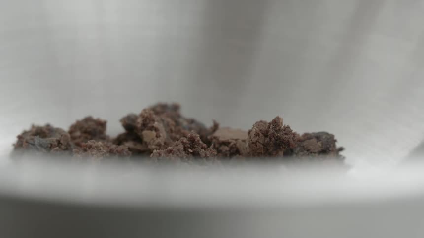 Pieces of chocolate dropped into a bowl