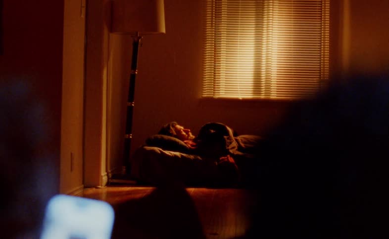 A young man lying down on a couch in a living room