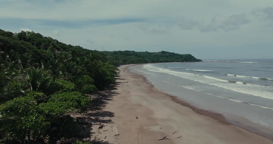 Aerial of waves gently rolling onto sandy shoreline on a remote beach