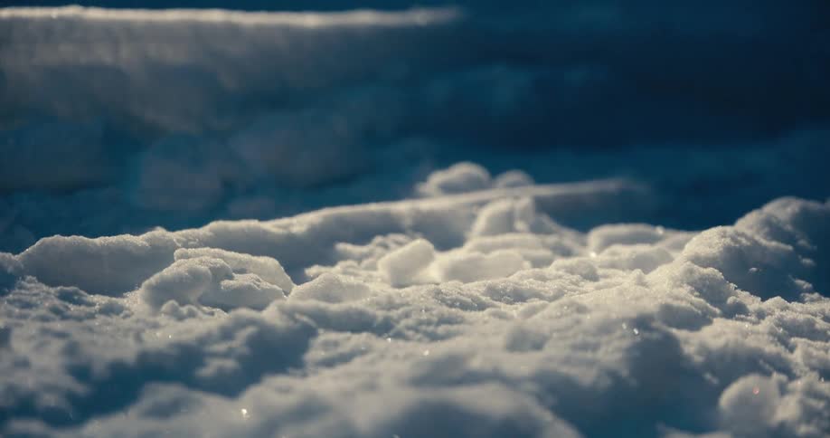 Snow piled on the ground reflects the soft ambient light