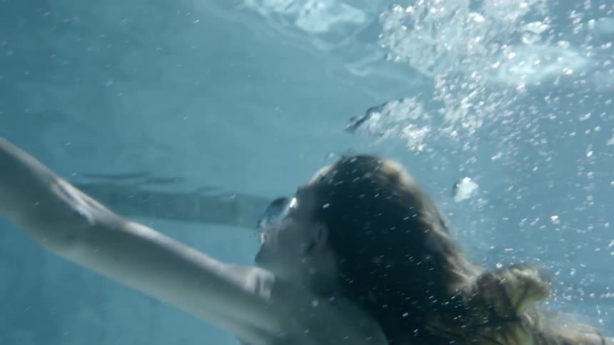 A woman dives and swims underwater