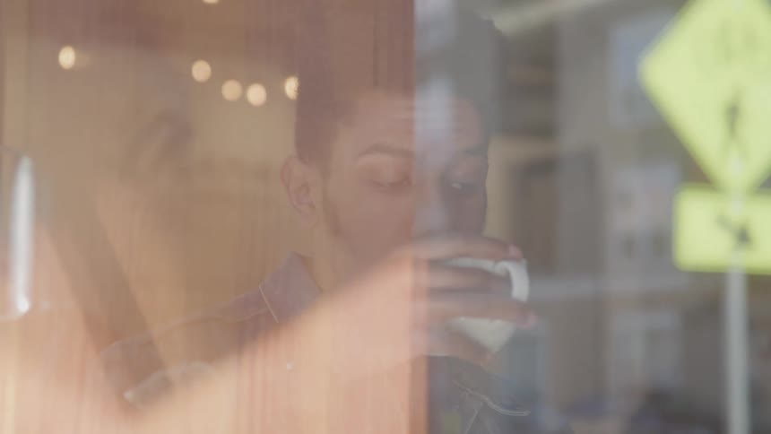 Man sitting down having a drink from a white mug
