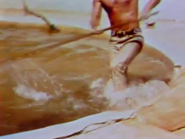 A man pokes at and then wrestles an alligator