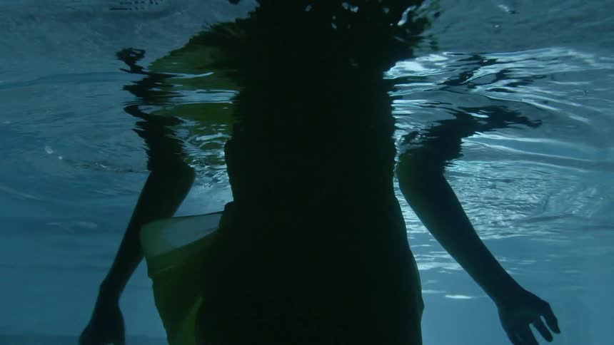 A woman is wading in the water