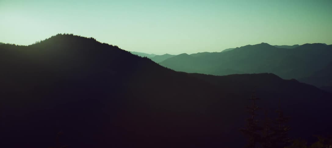 Layered dark mountain range with a clear sky on the horizon