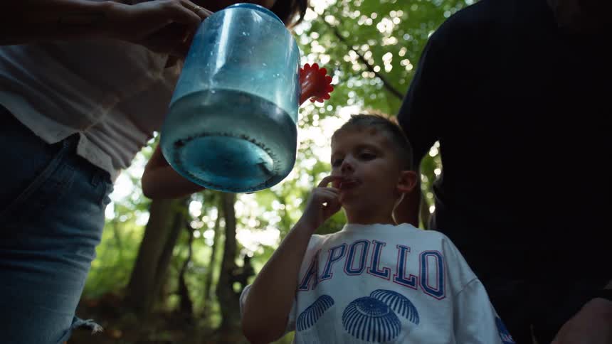 Boy accompanied by two adults in the middle of nature