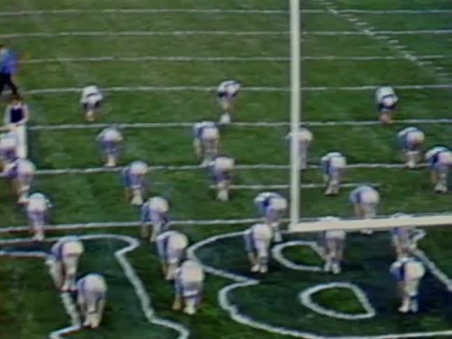 Football players doing stretches on field