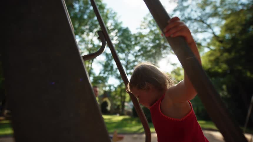Little girl climbing the stairs of an outdoor playground