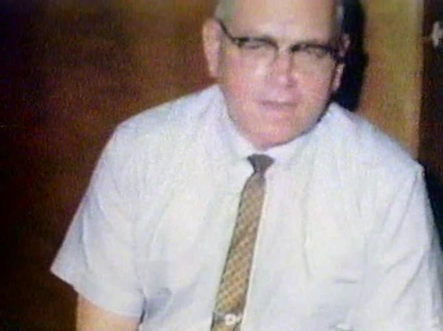 A man wearing glasses talks looking forward