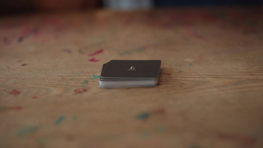 Hand picking up a letter on a wooden surface
