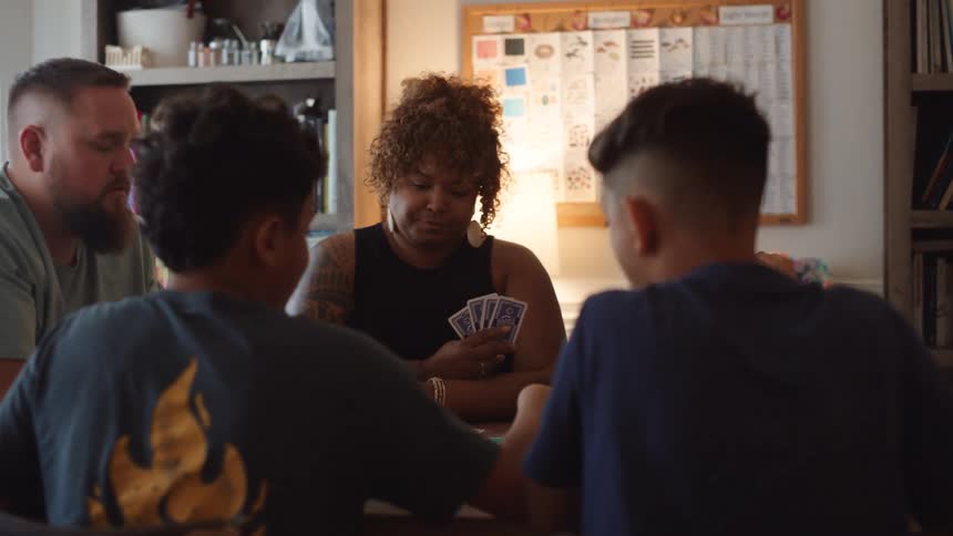 Family sitting around a table playing cards