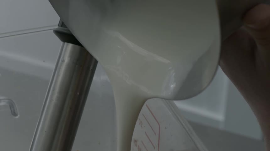 Milk is being poured into a large container