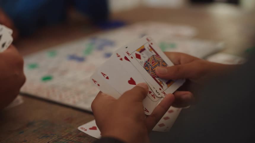 Little boy sitting at the table playing cards