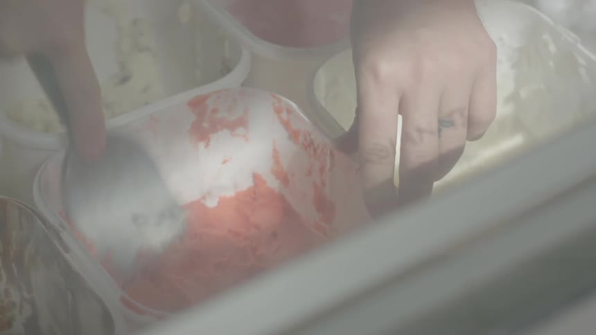 A person is mixing some ice cream in a parlor