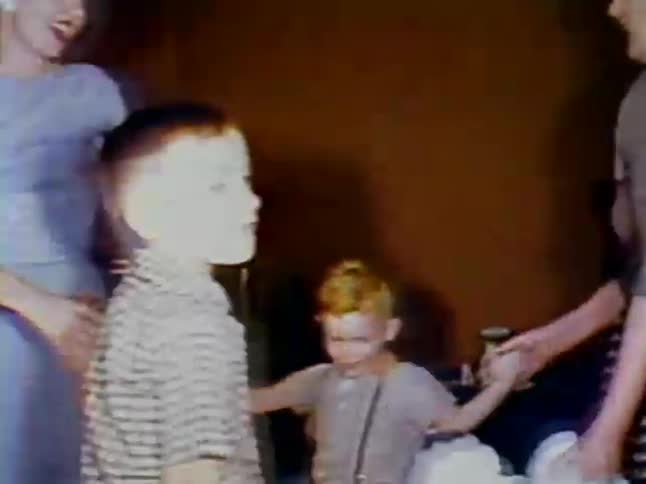 Two women hold hands with two boys and walk in a circle