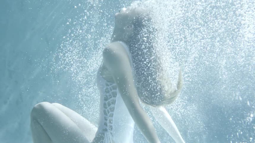 A woman falls backwards into the water then dives up