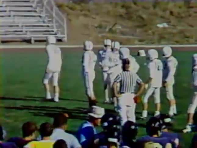 A football player runs from the sideline to join the huddle