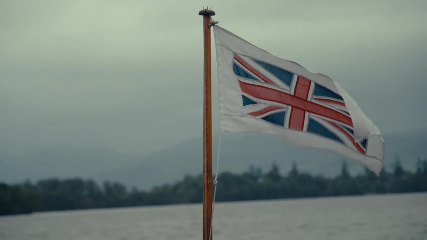 A waving british flag on a vehicle at sea during daytime