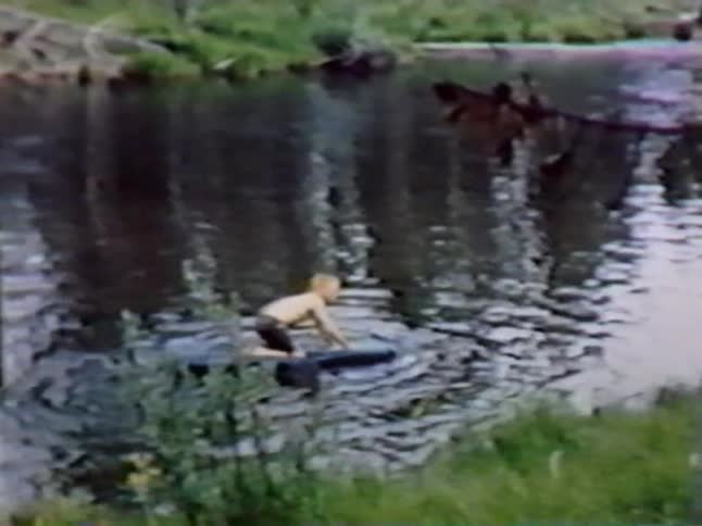 A child is floating in the water on a board