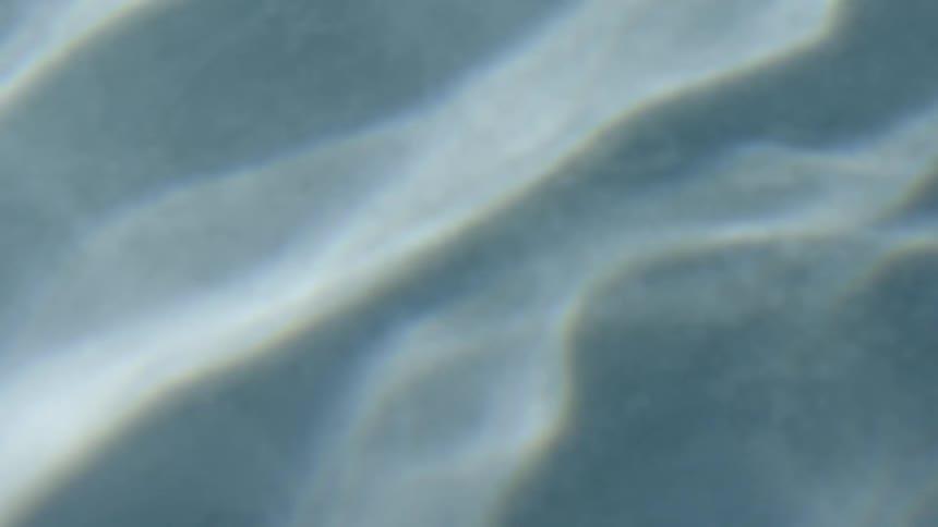The light is reflecting off the small waves in the water