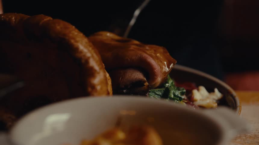 Close up of a person eating food while sitting at a table indoors