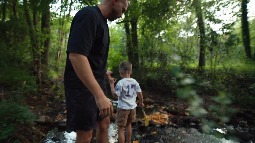 A family of four hikes through the woods through water