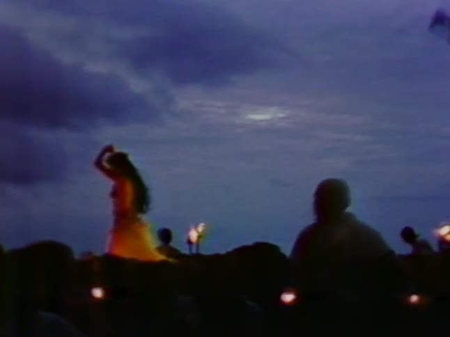 A hula dancer performs on stage at dawn