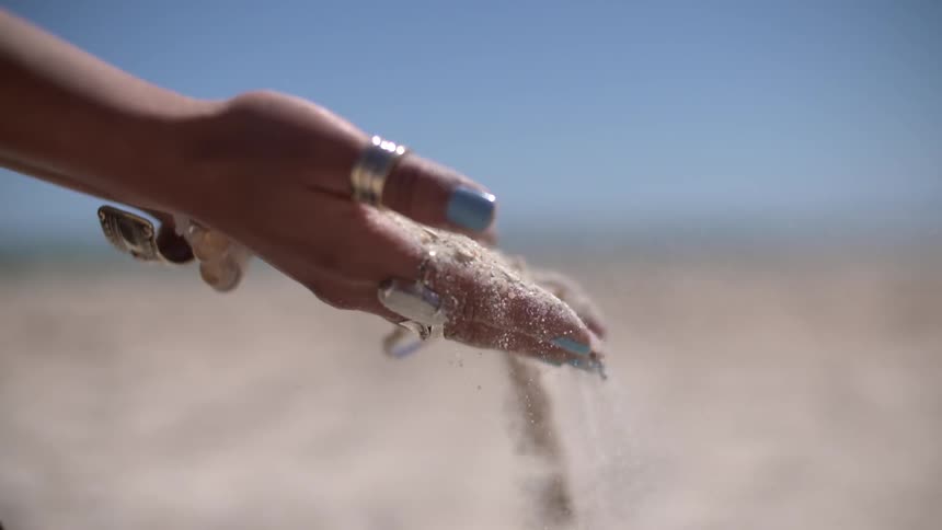 Woman with sand sliding off of her hands