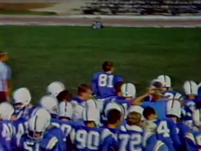 A large group of football players break huddle