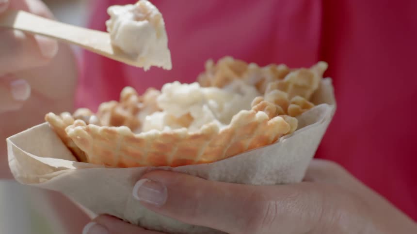A person is eating ice cream from a cone