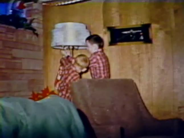 Two children turn on a lamp in the living room
